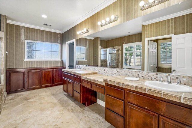 bathroom with wallpapered walls, visible vents, a shower stall, and a sink