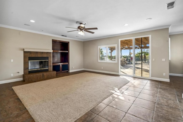 unfurnished living room with ceiling fan, visible vents, crown molding, a fireplace, and baseboards