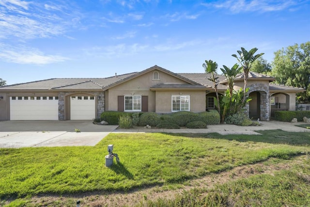 ranch-style house featuring a front yard, a garage, concrete driveway, stone siding, and stucco siding