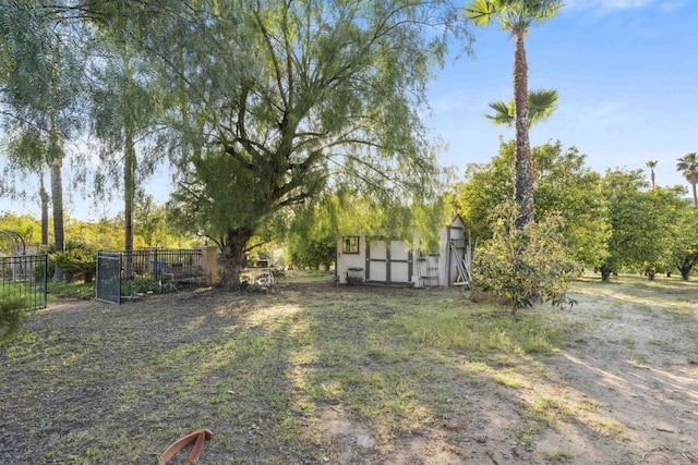 view of yard with a storage shed, fence, and an outdoor structure