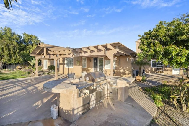 view of patio / terrace featuring an outdoor kitchen, a pergola, and a grill