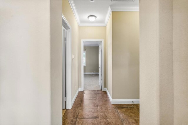 hallway with baseboards, ornamental molding, and visible vents