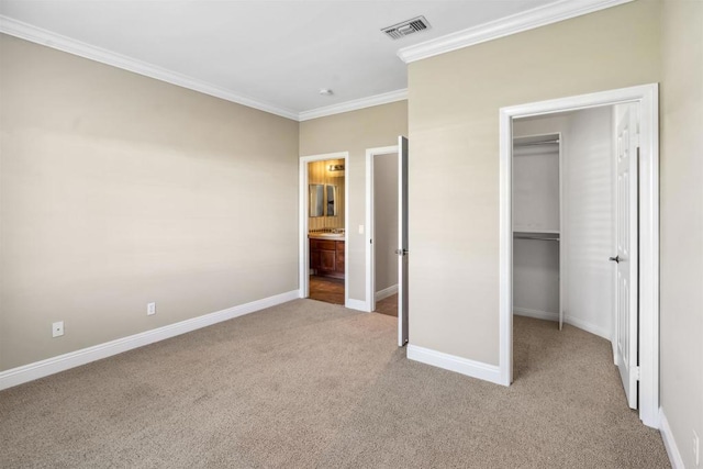 unfurnished bedroom with light colored carpet, ornamental molding, a spacious closet, and visible vents