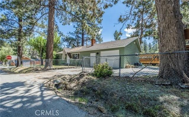 exterior space featuring fence, a chimney, driveway, and a garage