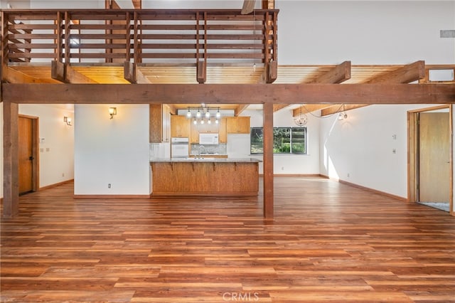 unfurnished living room with baseboards and wood finished floors