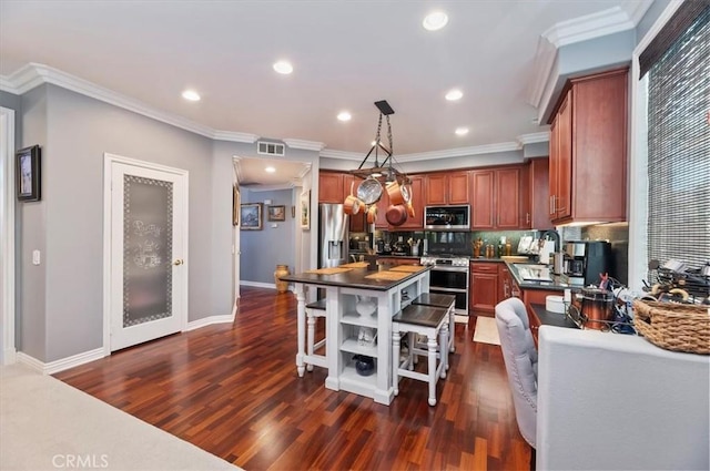 kitchen featuring dark countertops, appliances with stainless steel finishes, dark wood-style flooring, and visible vents