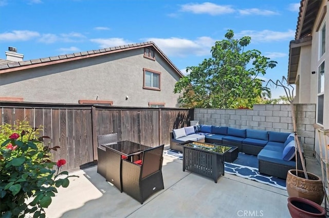 view of patio / terrace with a fenced backyard and an outdoor living space with a fire pit