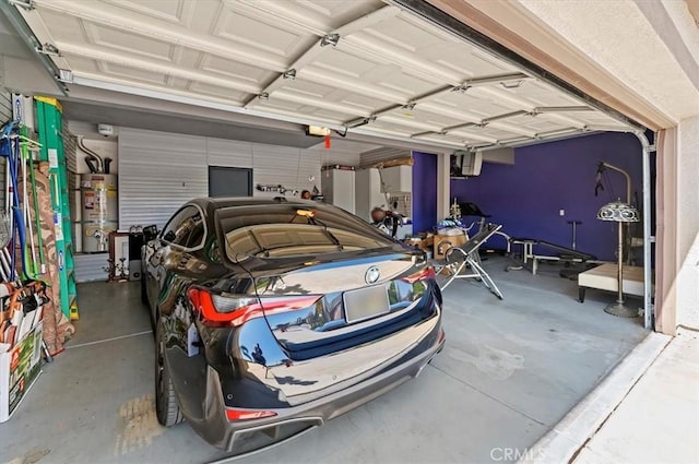 garage featuring water heater and a garage door opener