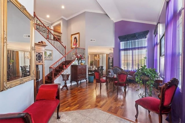 entrance foyer with visible vents, ornamental molding, stairs, and high vaulted ceiling