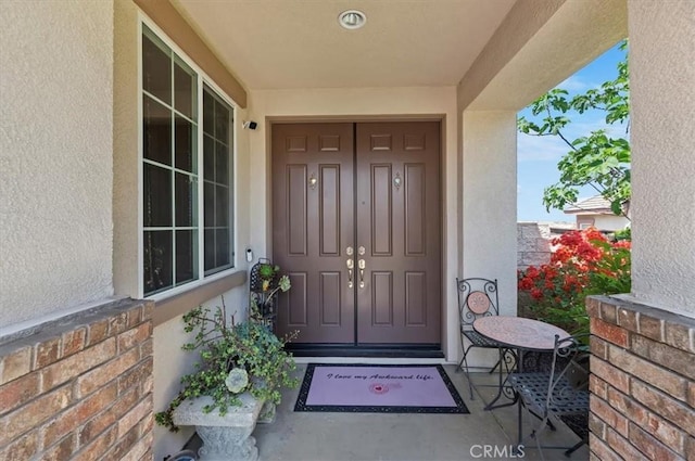 entrance to property featuring stucco siding