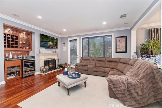 living area with crown molding, dark wood-style flooring, a dry bar, wine cooler, and visible vents