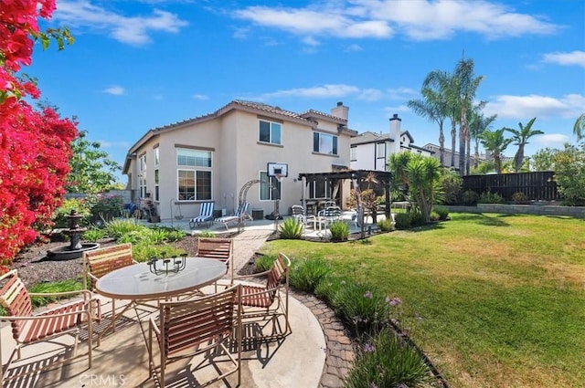 rear view of property featuring a chimney, a patio area, a fenced backyard, a yard, and stucco siding