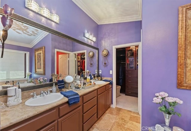full bath featuring a sink, crown molding, double vanity, and a spacious closet