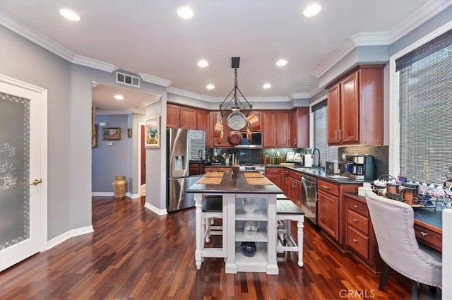 kitchen featuring dark countertops, appliances with stainless steel finishes, tasteful backsplash, a sink, and dark wood-type flooring
