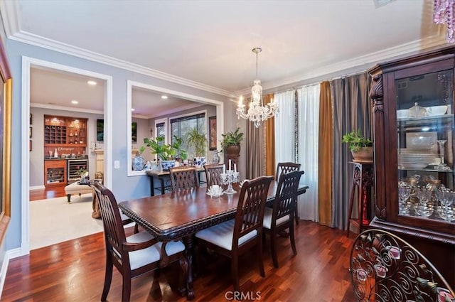 dining space with crown molding, a bar, dark wood-style floors, beverage cooler, and an inviting chandelier