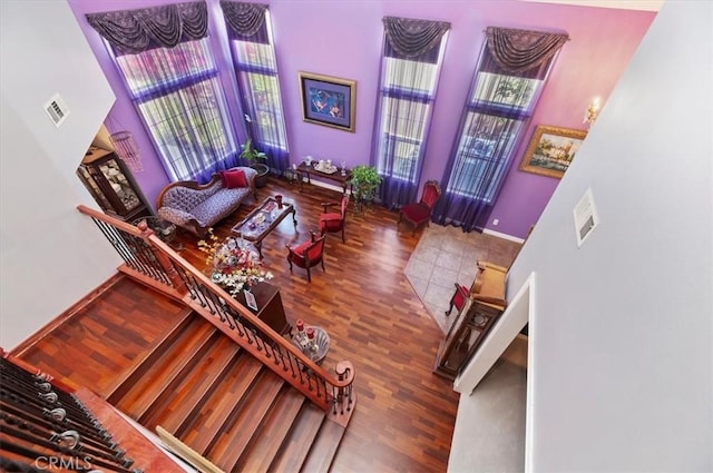 living area featuring baseboards, a high ceiling, and wood finished floors