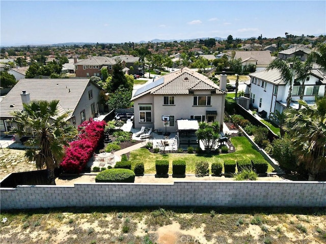 rear view of house featuring a residential view, a patio area, and stucco siding