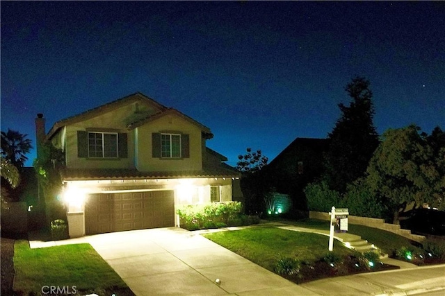view of front of house with a lawn, an attached garage, driveway, and stucco siding