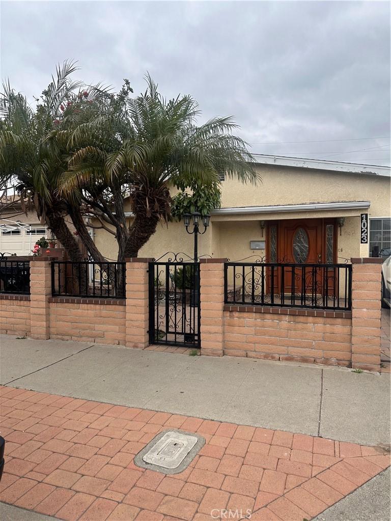 view of front of home featuring stucco siding, a gate, and a fenced front yard