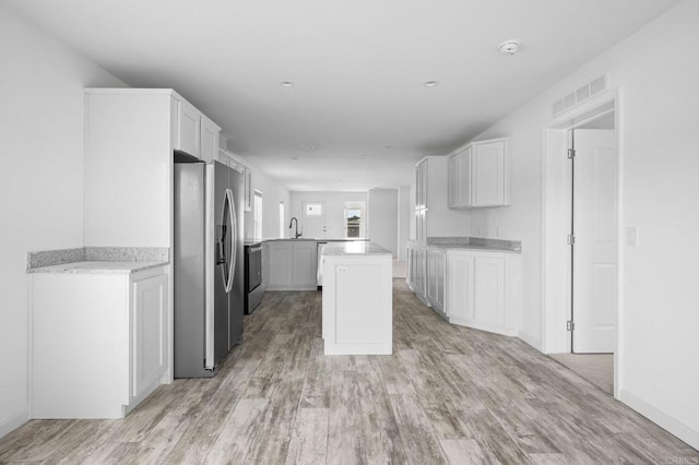 kitchen with white cabinetry, visible vents, appliances with stainless steel finishes, and light wood-style flooring