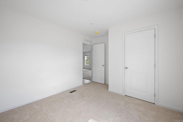 unfurnished bedroom featuring visible vents, carpet flooring, and baseboards