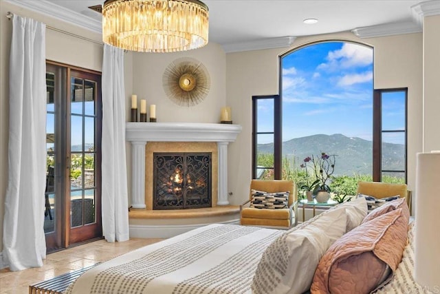 tiled bedroom with crown molding, a mountain view, a warm lit fireplace, and an inviting chandelier