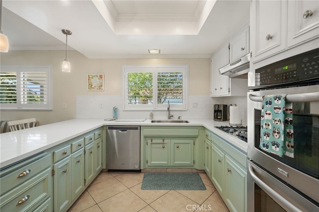 kitchen featuring a sink, appliances with stainless steel finishes, green cabinets, and backsplash