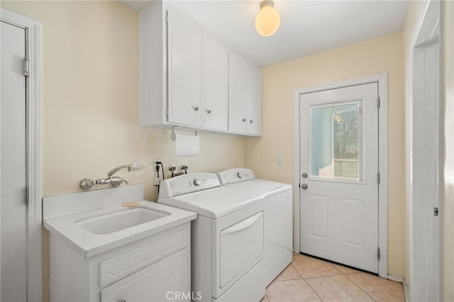 laundry room featuring a sink, cabinet space, light tile patterned floors, and washing machine and dryer
