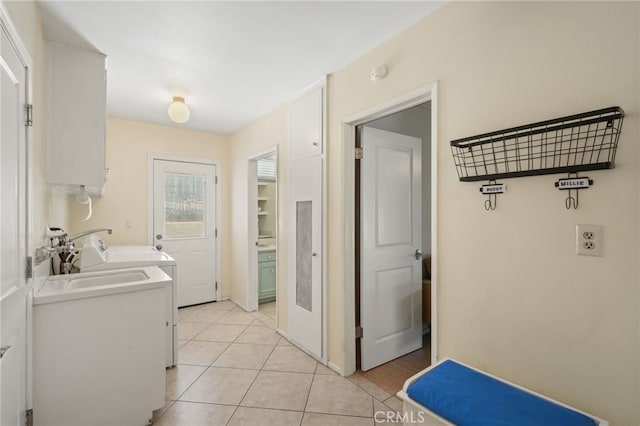 clothes washing area with laundry area, a sink, and light tile patterned floors