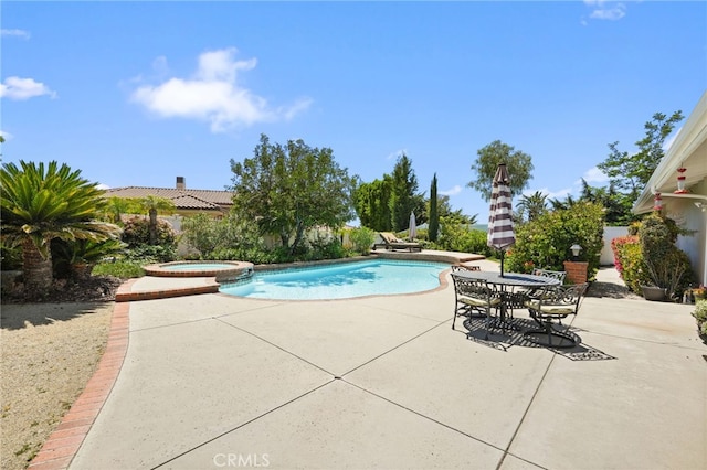 view of pool featuring a patio and a pool with connected hot tub