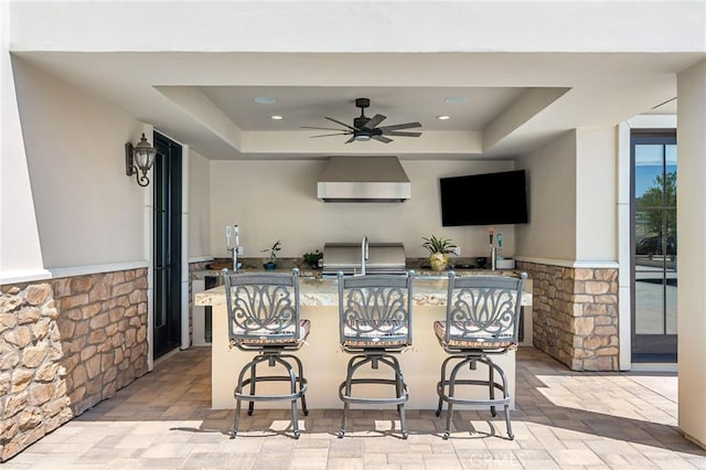 view of patio / terrace featuring ceiling fan, outdoor wet bar, and exterior kitchen