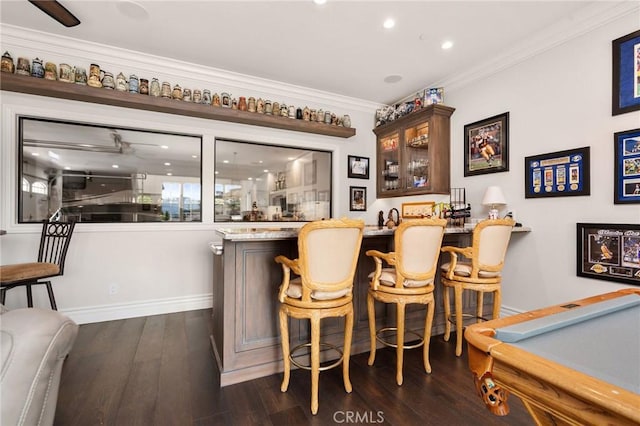 bar with recessed lighting, dark wood-type flooring, wet bar, baseboards, and ornamental molding