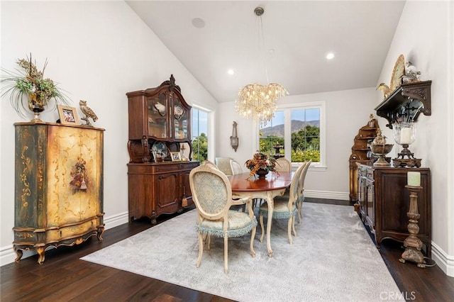 dining room with lofted ceiling, a wealth of natural light, a chandelier, and dark wood-style floors