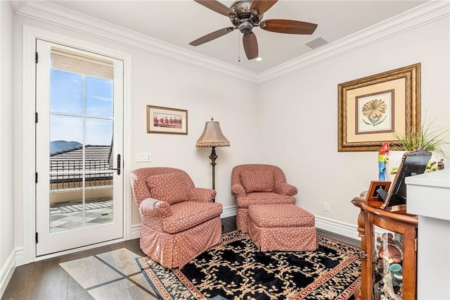 sitting room featuring ceiling fan, crown molding, visible vents, baseboards, and wood finished floors