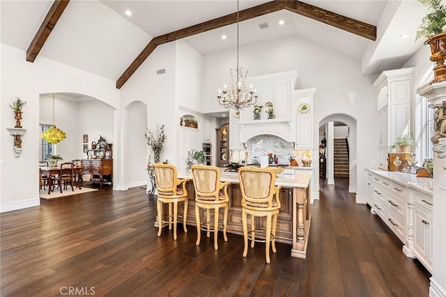 dining space featuring dark wood-style floors, arched walkways, high vaulted ceiling, and beam ceiling