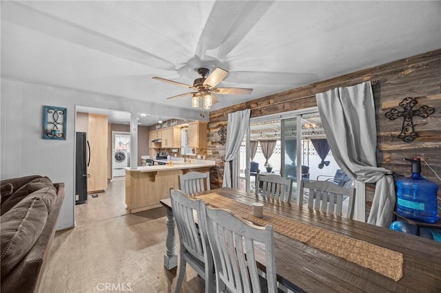 3520 Rosewood Pl, Riverside, CA 92506 - dining space featuring a ceiling fan, wood walls, washer / dryer, and light wood-style flooring
