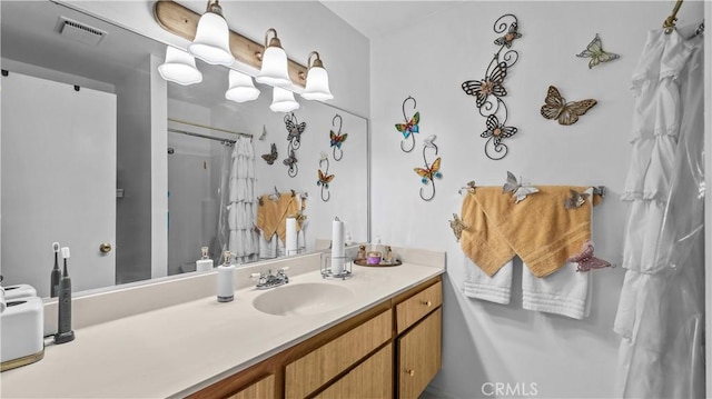 bathroom with visible vents, vanity, and curtained shower