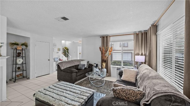 living area with visible vents, a textured ceiling, and light tile patterned flooring