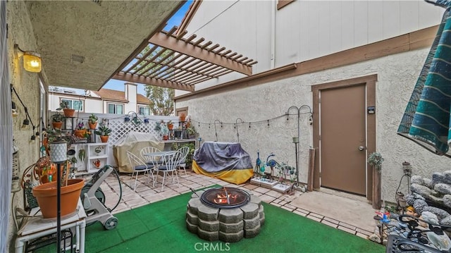 view of patio featuring a pergola and a fire pit