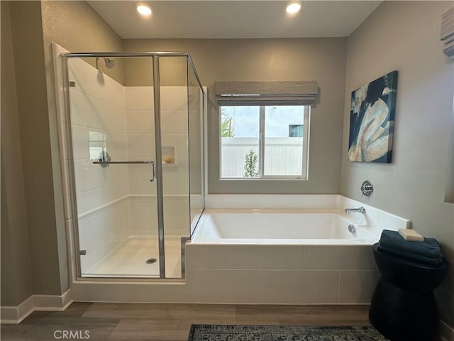 bathroom featuring recessed lighting, wood finished floors, a shower stall, and a garden tub