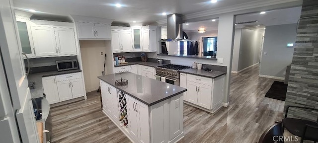 17011 Via, Los Caballeros, Riverside, CA 92504 - kitchen featuring island exhaust hood, appliances with stainless steel finishes, dark countertops, a center island, and crown molding