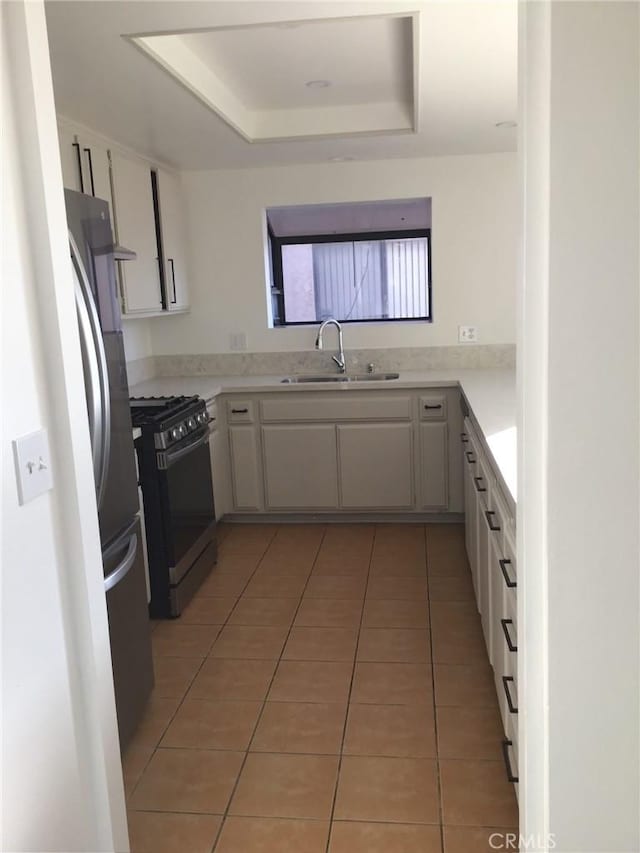 850W 157th Unit 6, Gardena, CA 90247 - kitchen with black range with gas cooktop, a sink, a raised ceiling, light countertops, and light tile patterned flooring