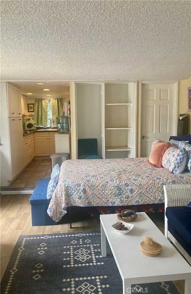 320 Metropole Ave Unit B, Avalon, CA 90704 - bedroom with a textured ceiling and wood finished floors