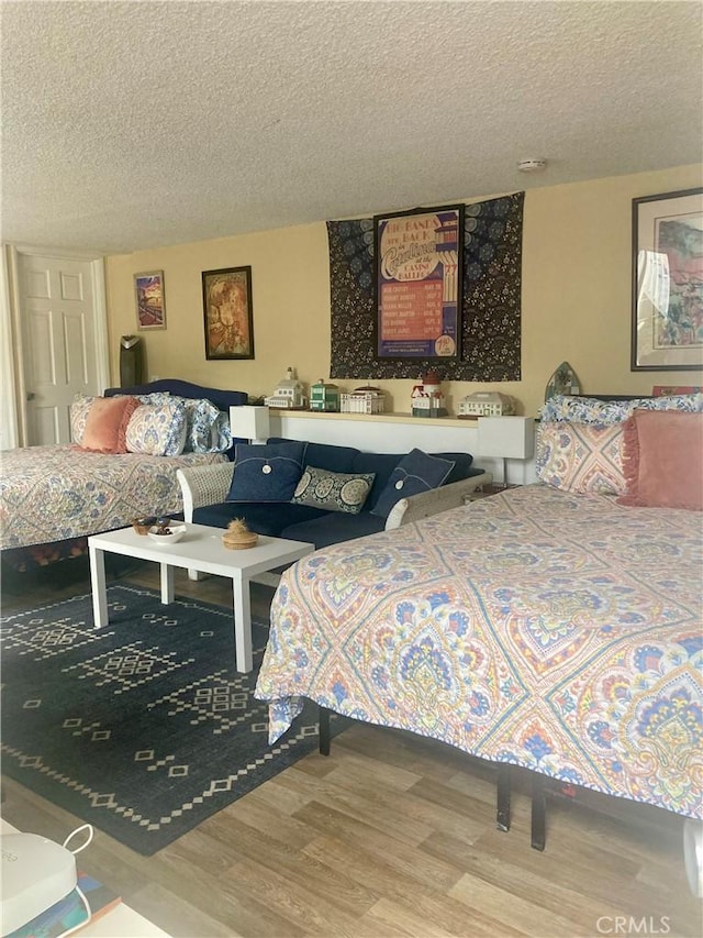 bedroom featuring a textured ceiling and wood finished floors