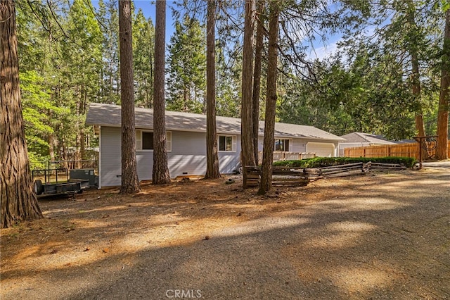 view of front of house with driveway, crawl space, a garage, and fence