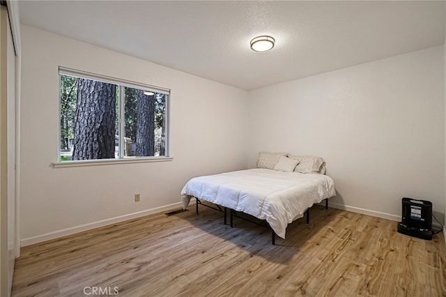 bedroom with wood finished floors and baseboards