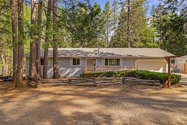 ranch-style home featuring a porch, a garage, and dirt driveway