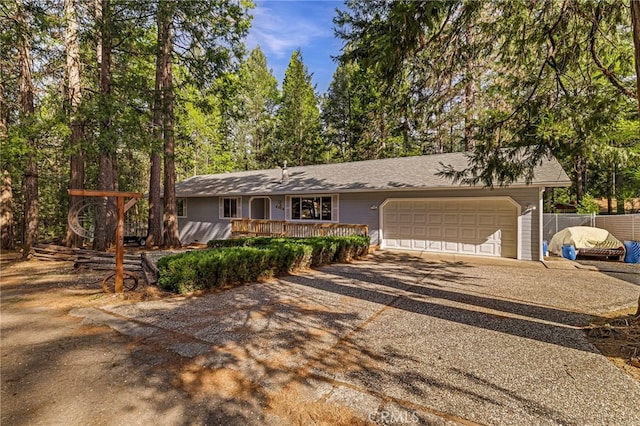 ranch-style house featuring concrete driveway, a garage, and fence