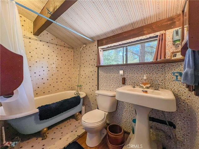 bathroom with toilet, vaulted ceiling with beams, and tile walls