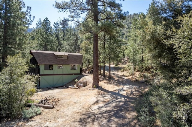 view of yard with a wooded view and an outdoor structure